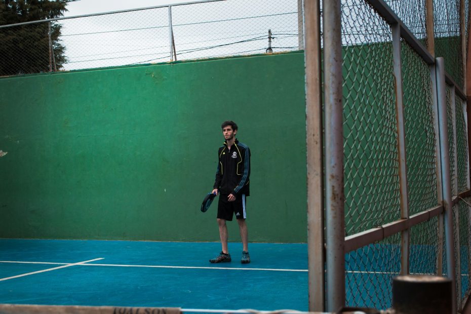 a man standing on a tennis court holding a racquet