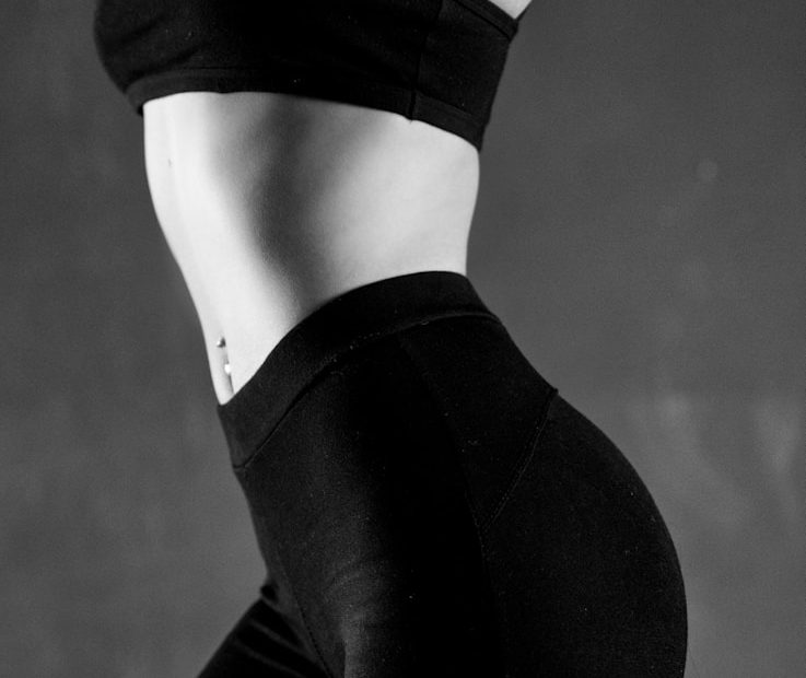 grayscale photo of person wearing sports bra and leggings