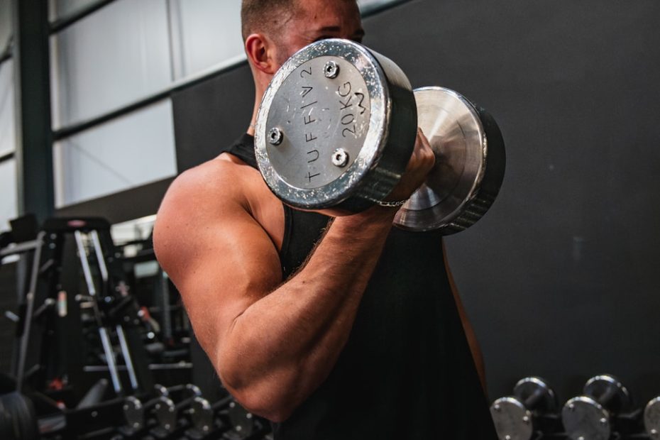 a man lifting a dumbbell in a gym